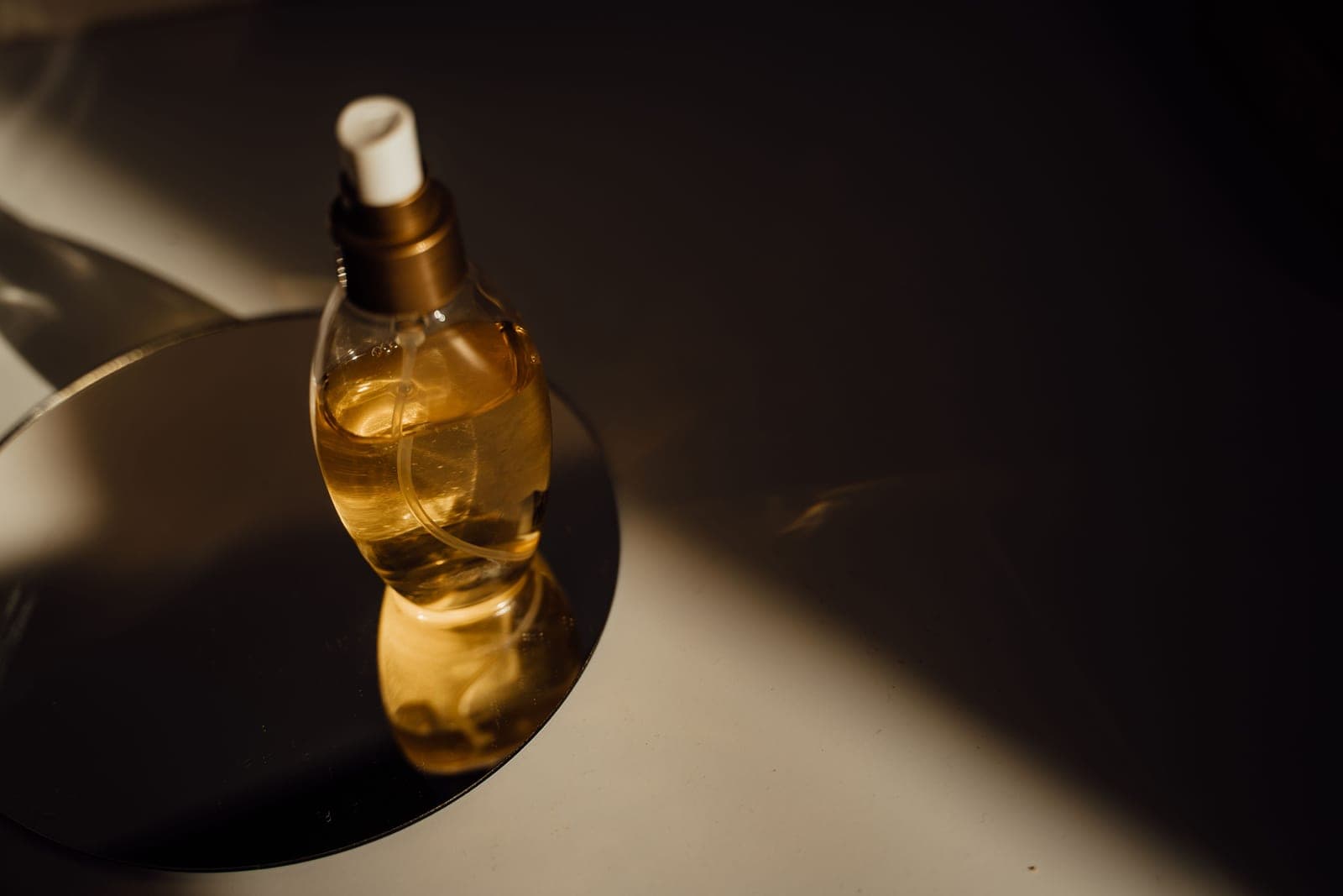 Amber glass fragrance bottles in low, moody apothecary light